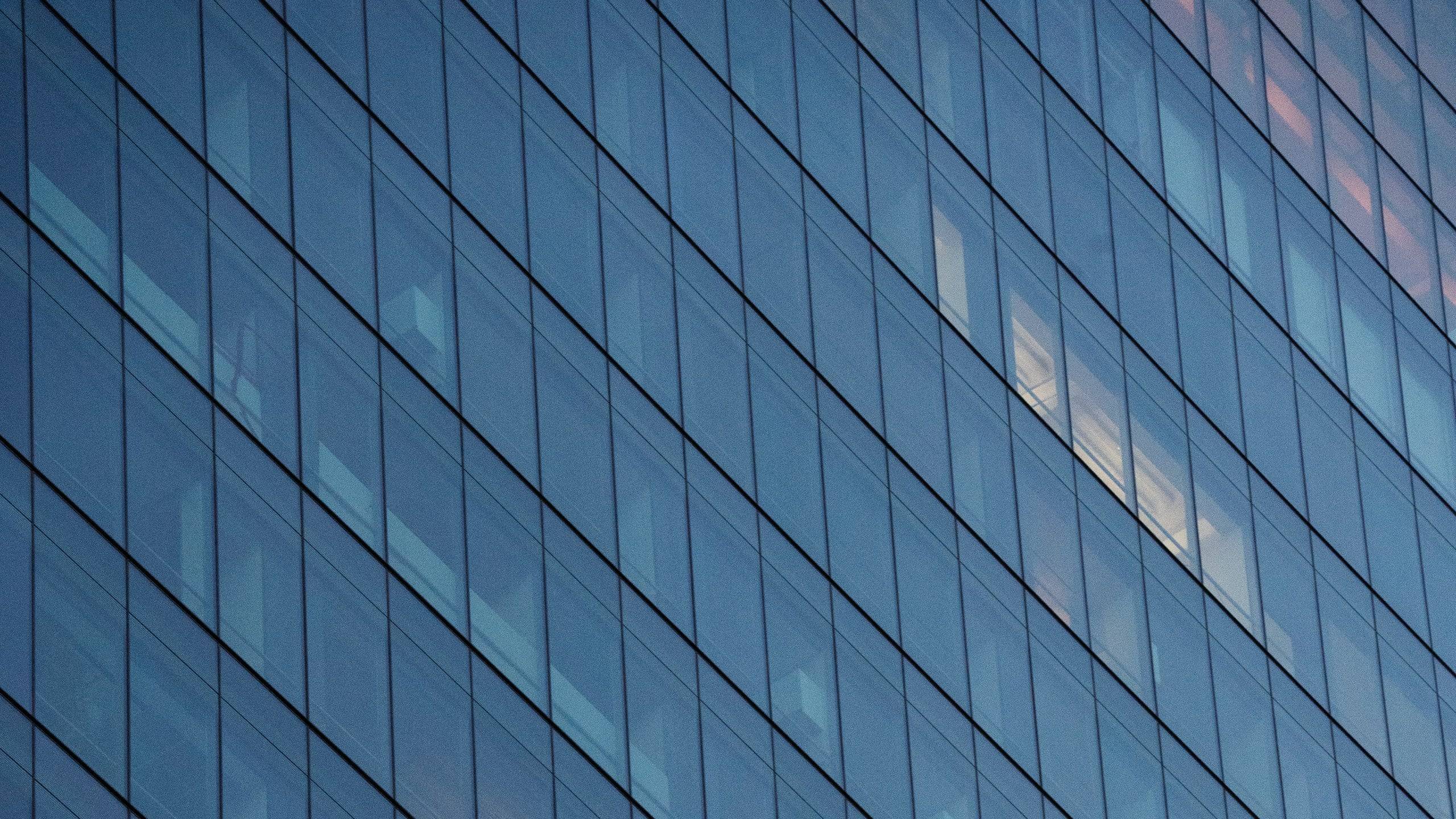 Glass facade of a modern office tower at dusk